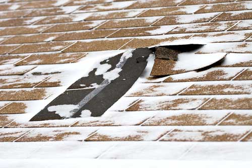 Has winter weather damaged your home?  shingles on a roof missing and torn off. 