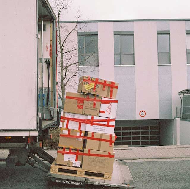 boxes being delivered from the back of a semi truck. 